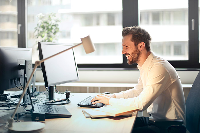 A smiling man working at a computer