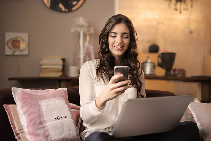 A woman holding a smartphone and smiling