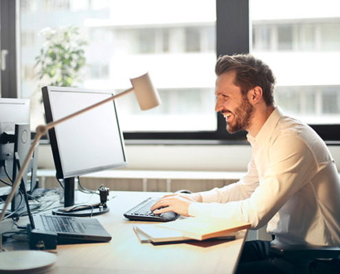 A smiling man working at a computer