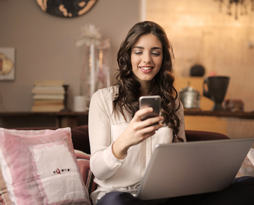 A woman holding a smartphone and smiling